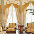 Классические шторы в гостиную с фигурным ламбрекеном фантазийной формы, декорированный аппликацией и мягкими ламбрекенами