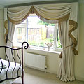 Классические шторы в спальню с мягким ламбрекеном и "хвостами" декорированные бахромой